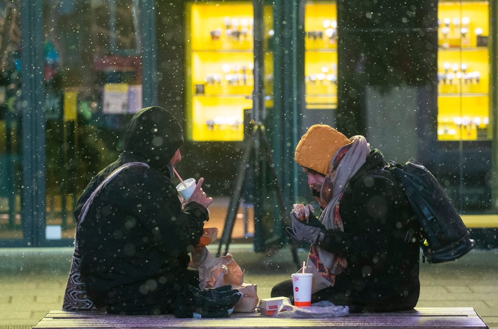 La gente come mientras cae nieve durante una tormenta de invierno en Times Square, Nueva York, el 31 de enero de 2021. Foto: Kena Betancur / AFP
